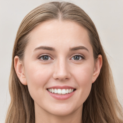 Joyful white young-adult female with long  brown hair and blue eyes