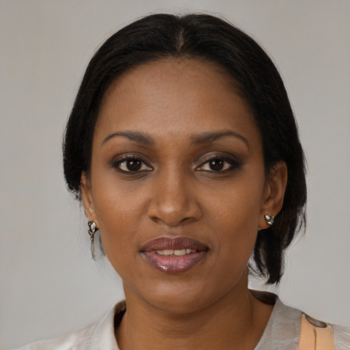 Joyful black adult female with medium  brown hair and brown eyes