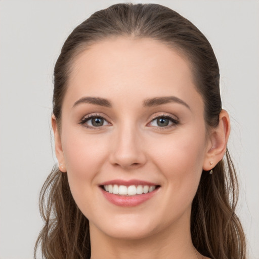 Joyful white young-adult female with long  brown hair and grey eyes