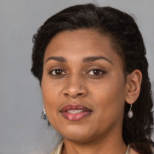 Joyful black adult female with medium  brown hair and brown eyes