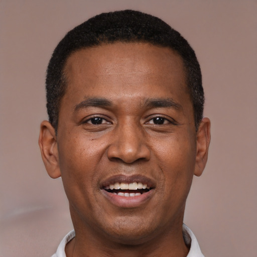 Joyful black young-adult male with short  black hair and brown eyes