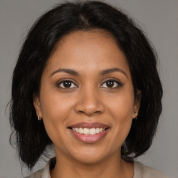 Joyful black young-adult female with medium  brown hair and brown eyes