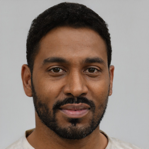 Joyful black young-adult male with short  black hair and brown eyes