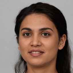 Joyful latino young-adult female with long  brown hair and brown eyes