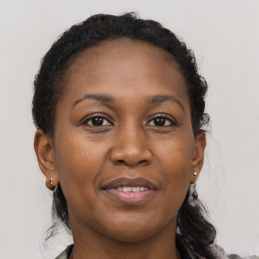 Joyful black adult female with long  brown hair and brown eyes