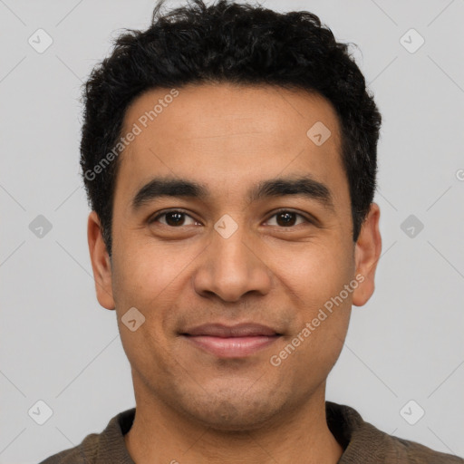 Joyful latino young-adult male with short  black hair and brown eyes