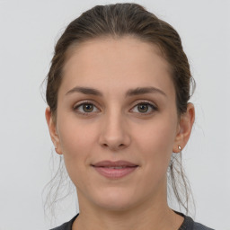 Joyful white young-adult female with medium  brown hair and grey eyes