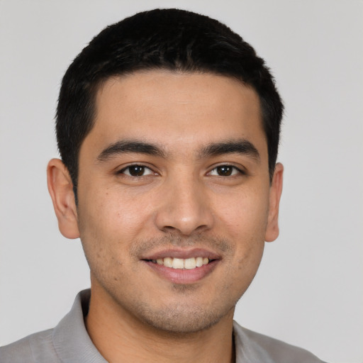 Joyful latino young-adult male with short  black hair and brown eyes