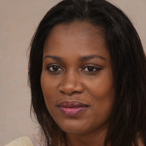 Joyful black young-adult female with long  brown hair and brown eyes