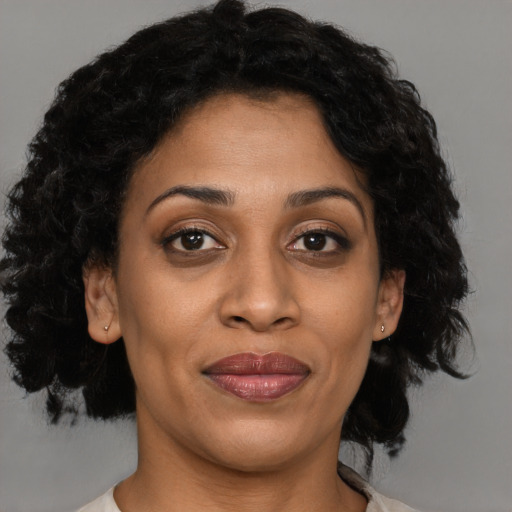 Joyful black adult female with medium  brown hair and brown eyes