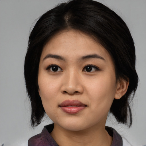 Joyful asian young-adult female with medium  black hair and brown eyes