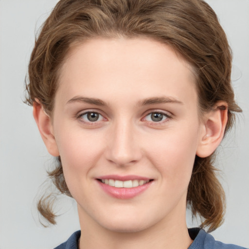 Joyful white young-adult female with medium  brown hair and grey eyes