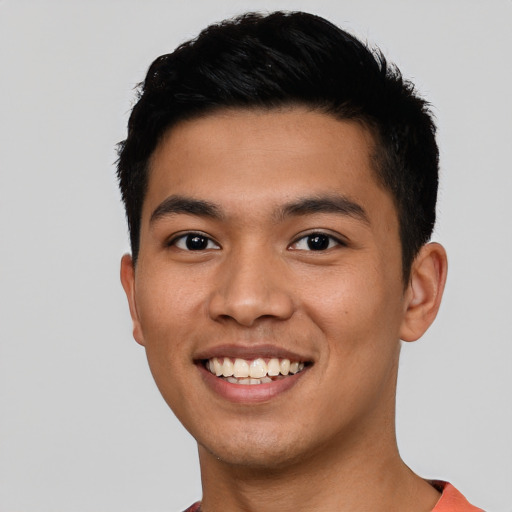 Joyful latino young-adult male with short  black hair and brown eyes