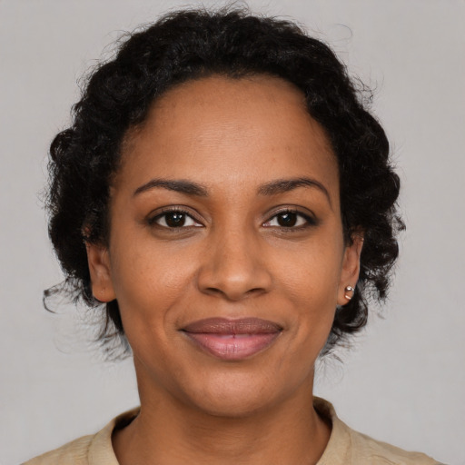 Joyful black adult female with medium  brown hair and brown eyes