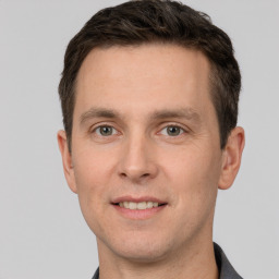 Joyful white young-adult male with short  brown hair and grey eyes