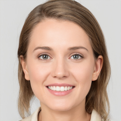 Joyful white young-adult female with medium  brown hair and grey eyes