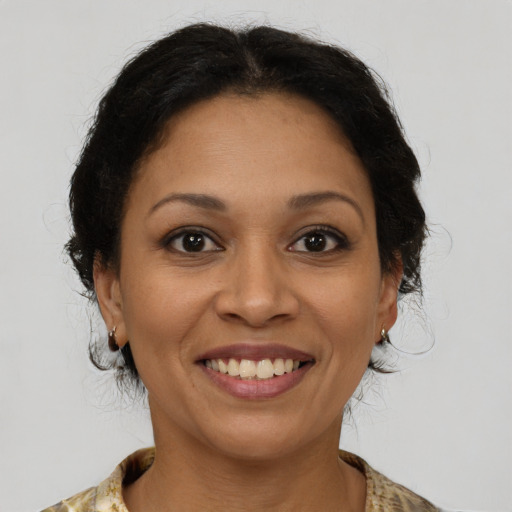 Joyful latino adult female with medium  brown hair and brown eyes