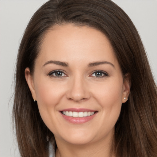 Joyful white young-adult female with long  brown hair and brown eyes