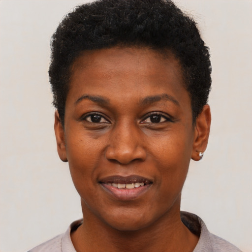 Joyful black young-adult female with short  black hair and brown eyes