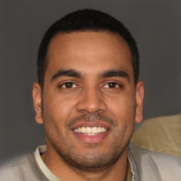 Joyful latino young-adult male with short  brown hair and brown eyes