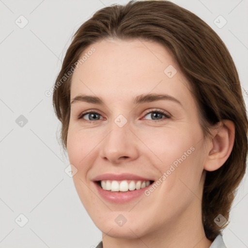 Joyful white young-adult female with medium  brown hair and grey eyes