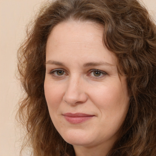 Joyful white adult female with long  brown hair and brown eyes