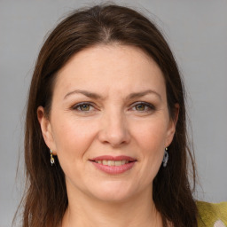 Joyful white adult female with medium  brown hair and grey eyes