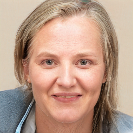 Joyful white adult female with medium  brown hair and blue eyes