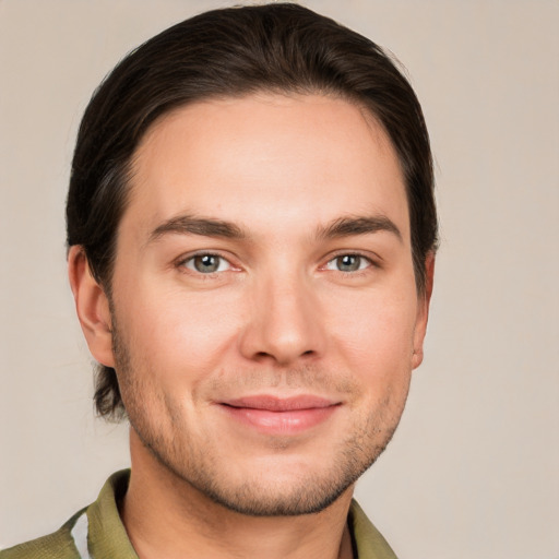 Joyful white young-adult male with short  brown hair and grey eyes