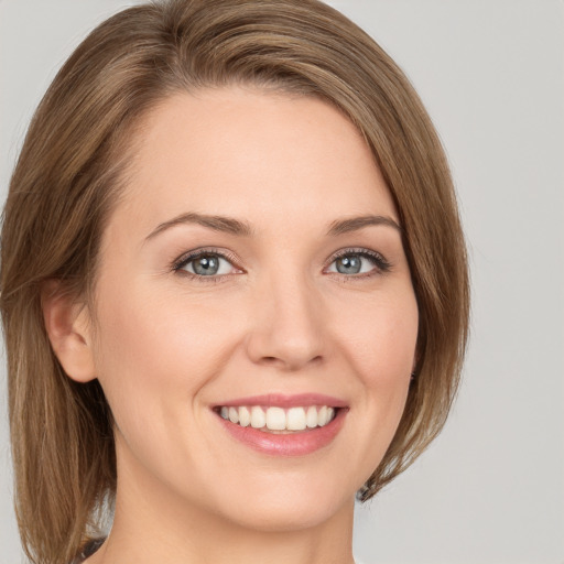 Joyful white young-adult female with medium  brown hair and green eyes