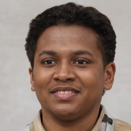 Joyful latino young-adult male with short  brown hair and brown eyes