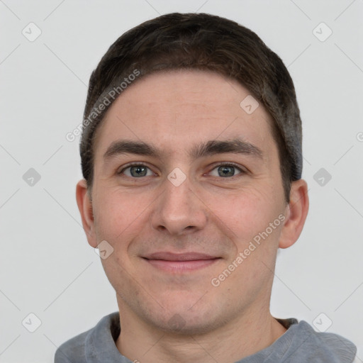 Joyful white young-adult male with short  brown hair and grey eyes