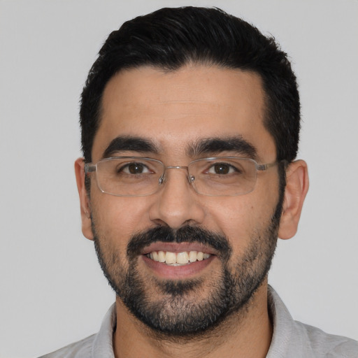 Joyful latino young-adult male with short  black hair and brown eyes