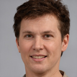 Joyful white adult male with short  brown hair and grey eyes