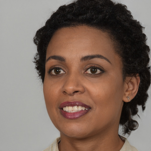Joyful black young-adult female with medium  black hair and brown eyes