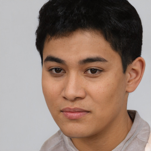 Joyful latino young-adult male with short  black hair and brown eyes