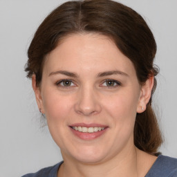 Joyful white young-adult female with medium  brown hair and grey eyes