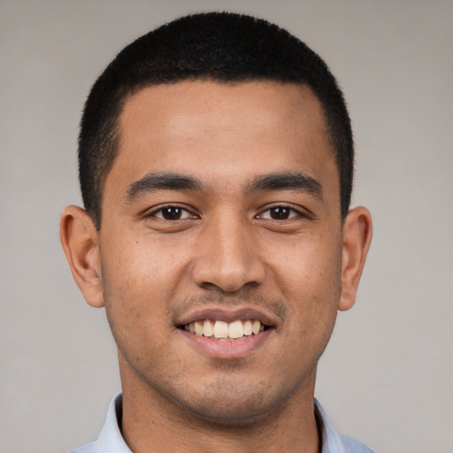 Joyful latino young-adult male with short  brown hair and brown eyes