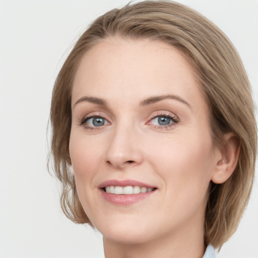 Joyful white young-adult female with medium  brown hair and blue eyes