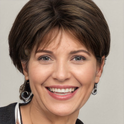 Joyful white adult female with medium  brown hair and grey eyes