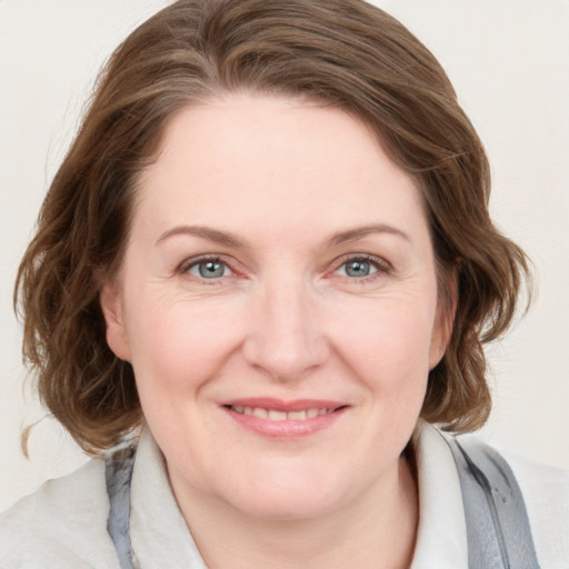 Joyful white young-adult female with medium  brown hair and blue eyes