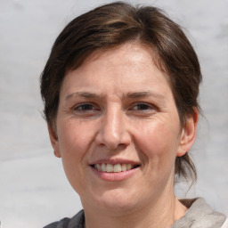 Joyful white adult female with medium  brown hair and grey eyes