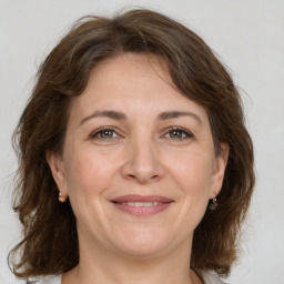 Joyful white adult female with medium  brown hair and grey eyes