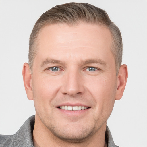 Joyful white adult male with short  brown hair and grey eyes