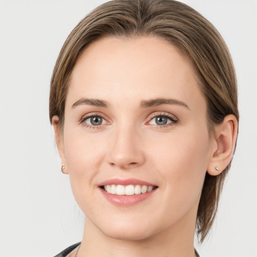 Joyful white young-adult female with medium  brown hair and grey eyes