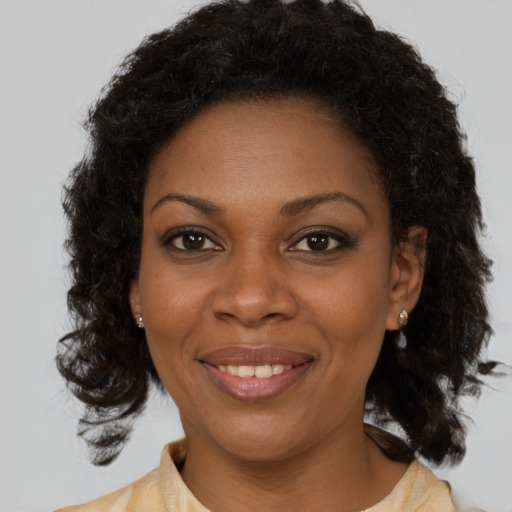 Joyful black young-adult female with medium  brown hair and brown eyes