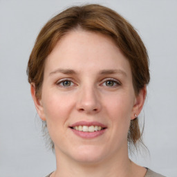 Joyful white young-adult female with medium  brown hair and grey eyes