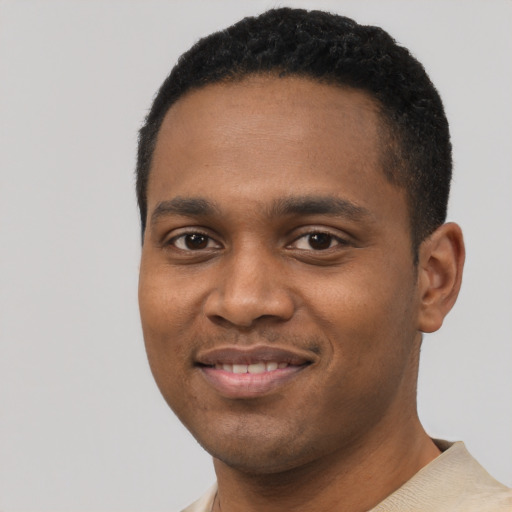 Joyful black young-adult male with short  black hair and brown eyes
