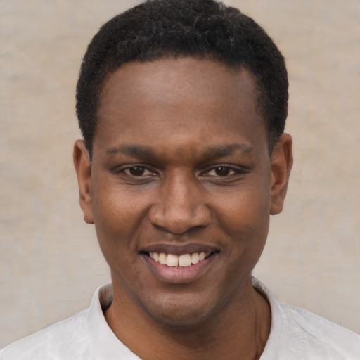 Joyful black young-adult male with short  black hair and brown eyes