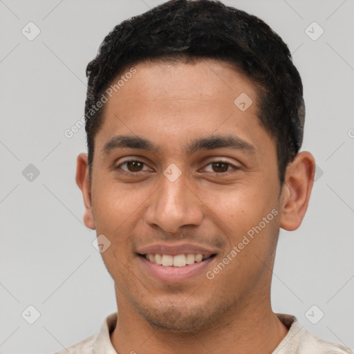 Joyful latino young-adult male with short  brown hair and brown eyes